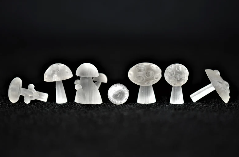 3D printed mushroom dice inclusions on black background